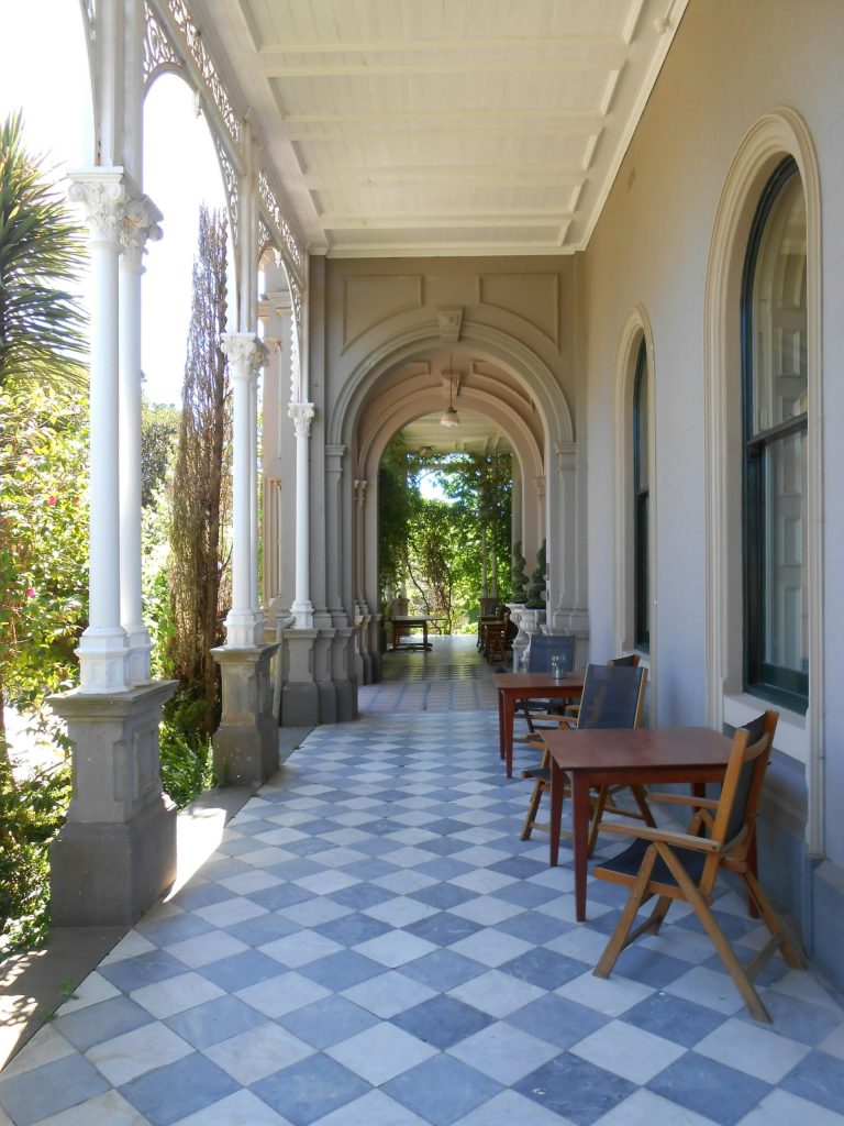 a porch with a table and chairs on it